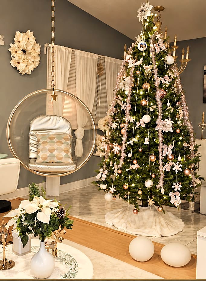 Christmas tree decorated in blush pink, gold and white beside a hanging egg chair