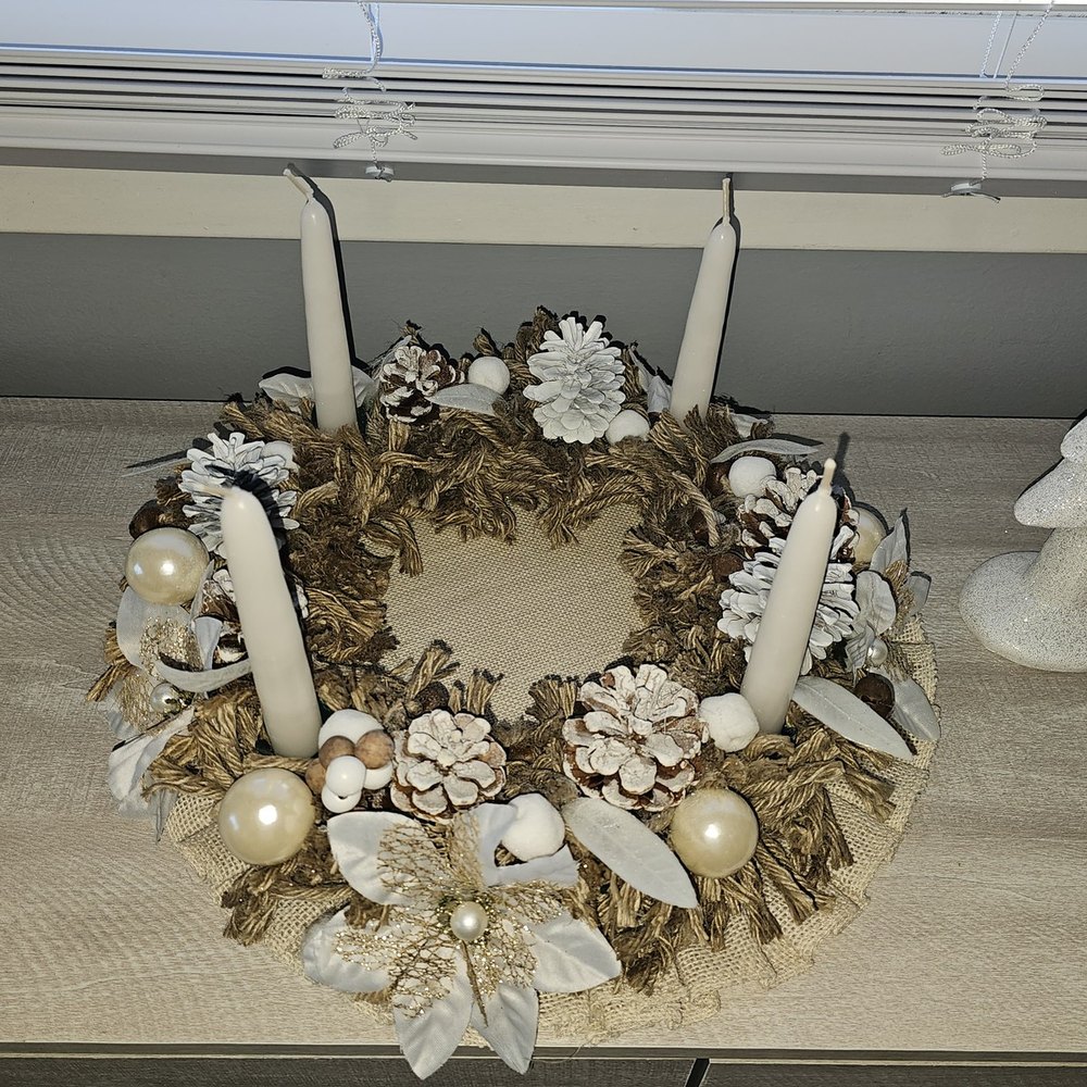 Handmade tabletop advent wreath of woven jute with four white taper candles and pearl ornaments