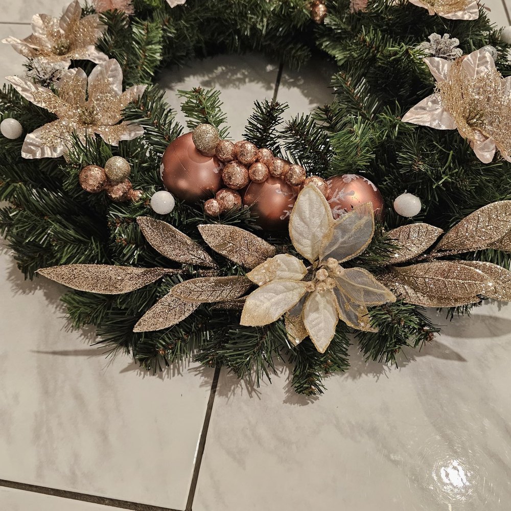 Handmade wreath with rose-gold ball ornaments, glittered blush poinsettias and metallic foliage