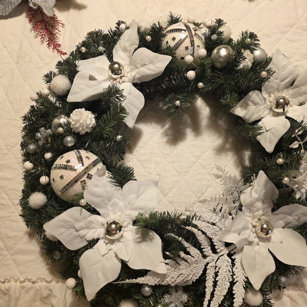 Handmade wreath with white poinsettias, silver mirrored ball ornaments, glitter snowflakes and frosted ferns